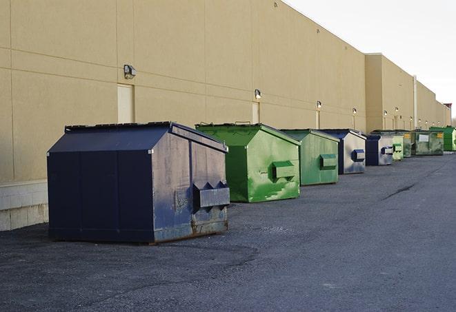 a team of workers hauls broken concrete in wheelbarrows to the dumpster in Dearborn Heights, MI